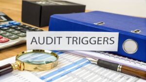 SMSF audit triggers concept with magnifying glass, calculator, and compliance documents on desk